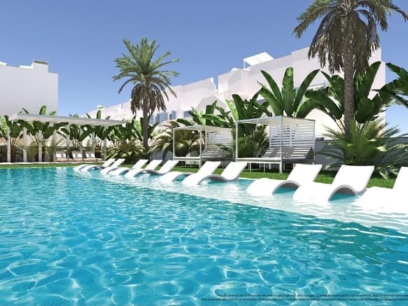 Communal swimming pool with submerged loungers and palm trees in Torre de la Horadada, Alicante