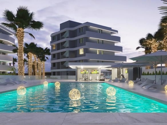 Evening rendering of an illuminated communal pool beside curved white apartment buildings in El Raso, Guardamar del Segura, Alicante