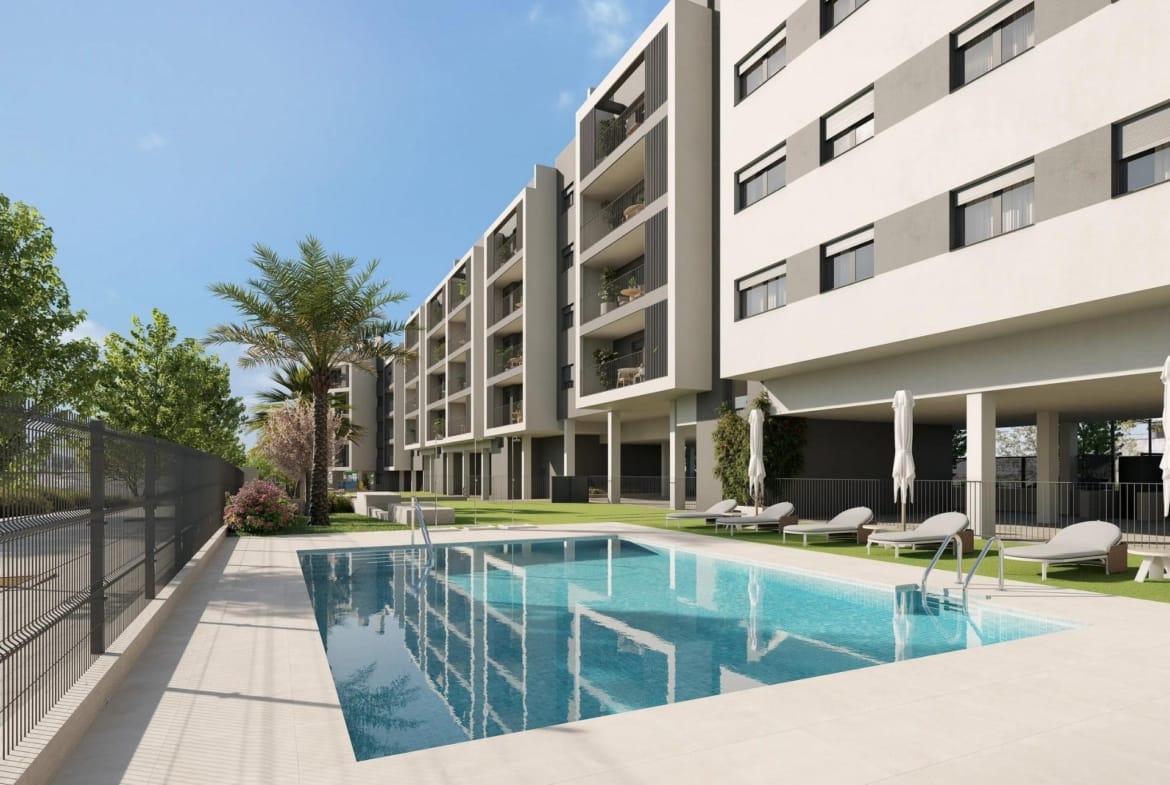 Communal swimming pool with sun loungers beside apartment balconies in San Agustín, Alicante
