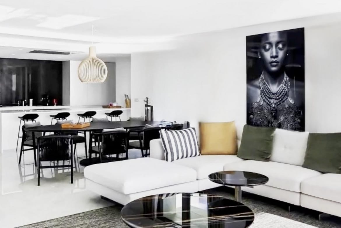 Living and dining area with a white sofa, dark dining chairs and pendant lighting in Relleu, Alicante