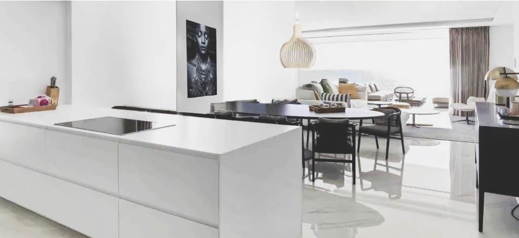 White kitchen island beside an open living and dining area in Relleu, Alicante