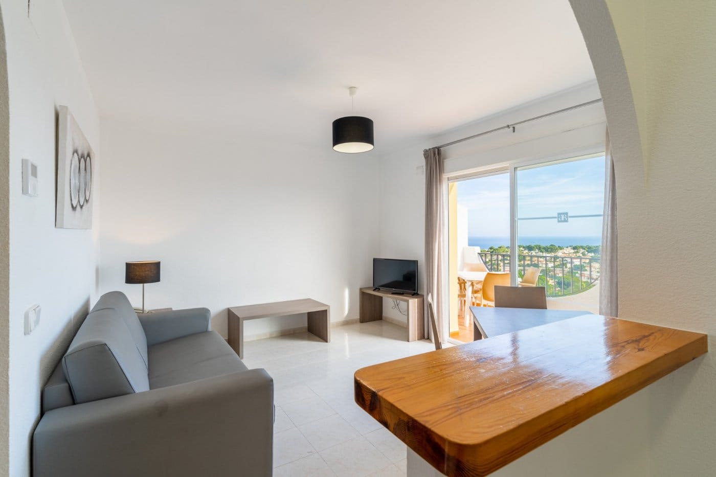Open living room and kitchen breakfast bar facing a terrace with sea views in Gran Sol, Calpe, Alicante