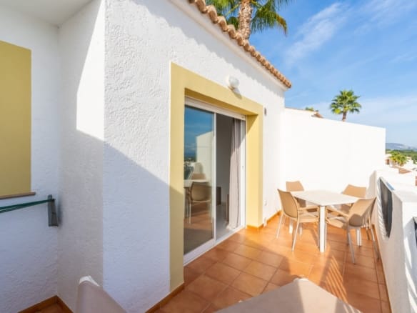 Tiled terrace with a dining table beside sliding doors and a white balustrade in Gran Sol, Calpe, Alicante