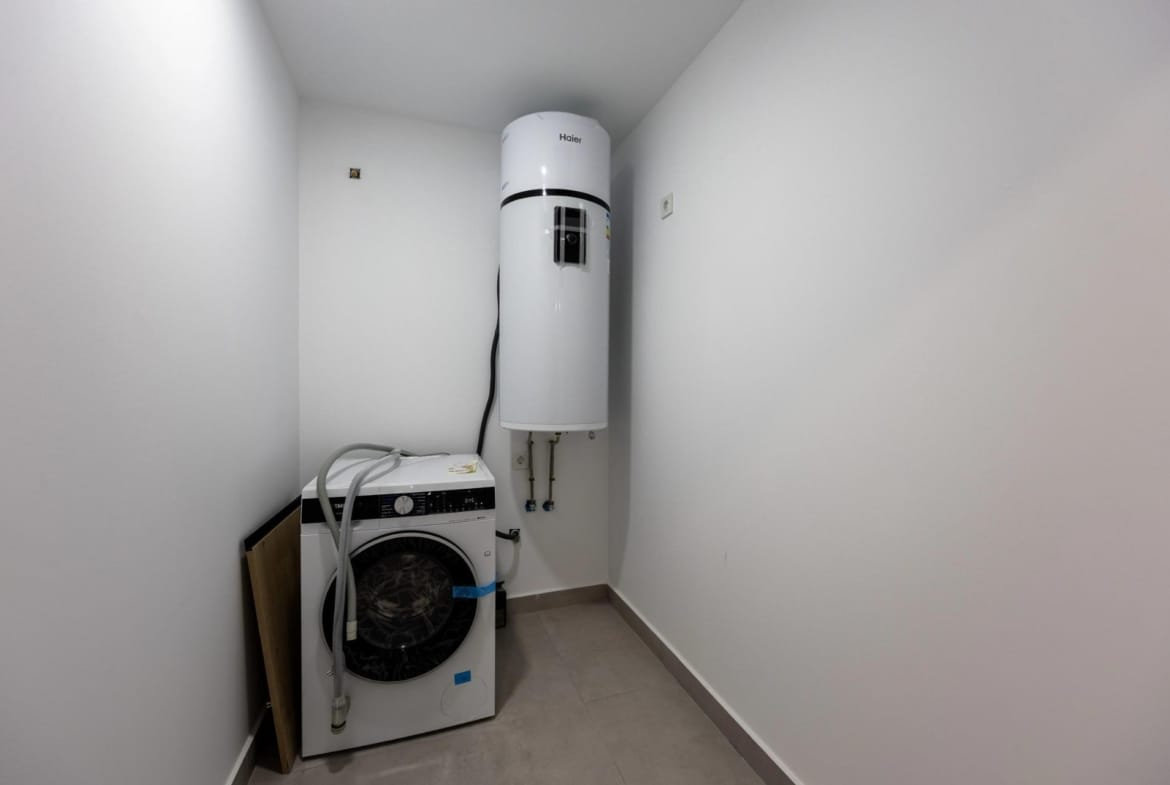 Laundry room with washing machine and hot-water cylinder