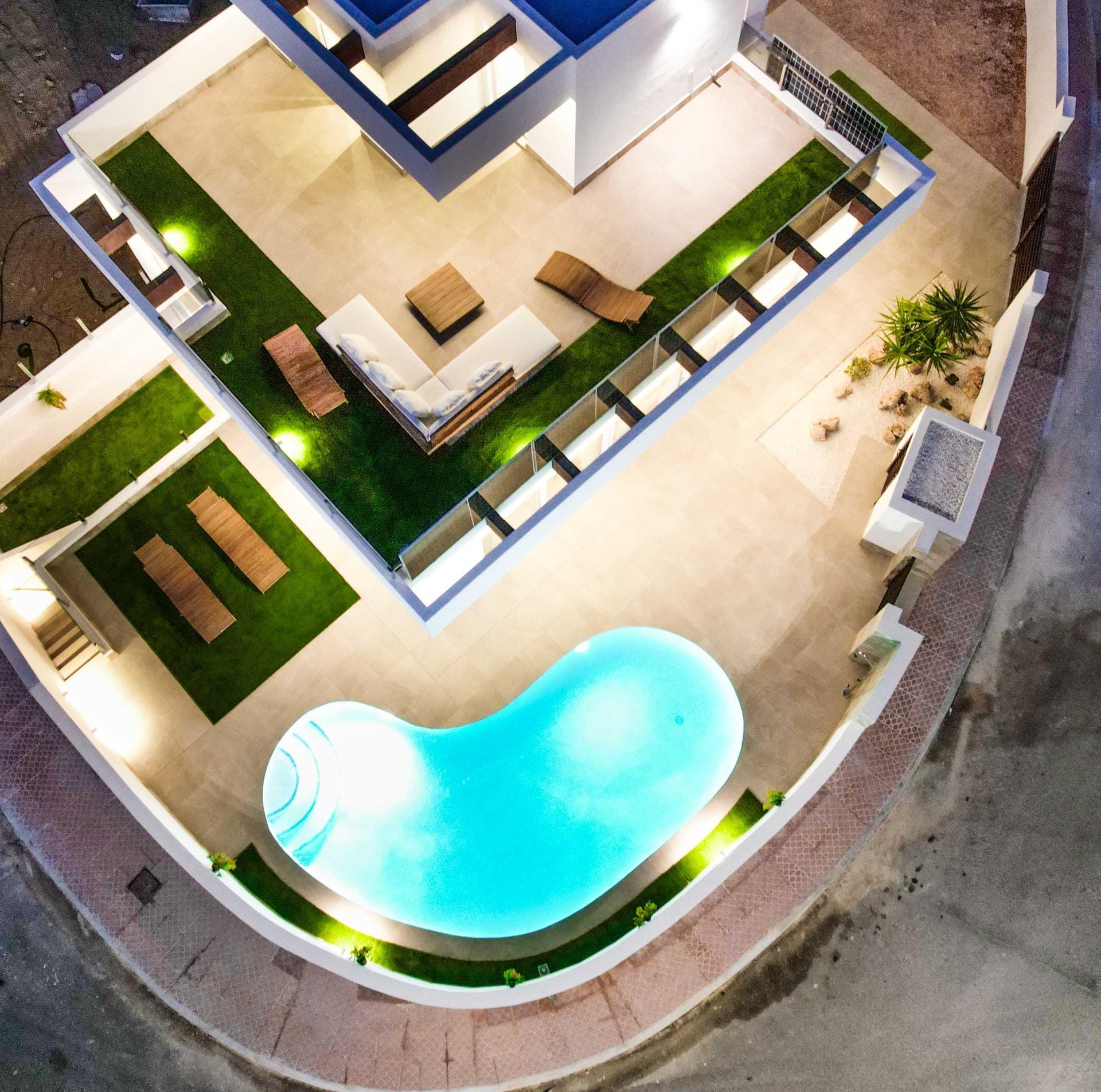 Overhead evening view of the villa and curved pool terrace in La Marquesa, Ciudad Quesada, Alicante
