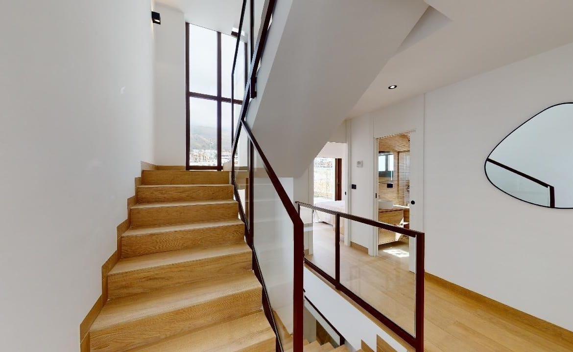 Internal staircase with wood treads and dark balustrade in Campana Garden, Finestrat, Alicante