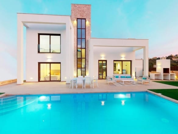 Villa and illuminated private pool at dusk in Campana Garden, Finestrat, Alicante