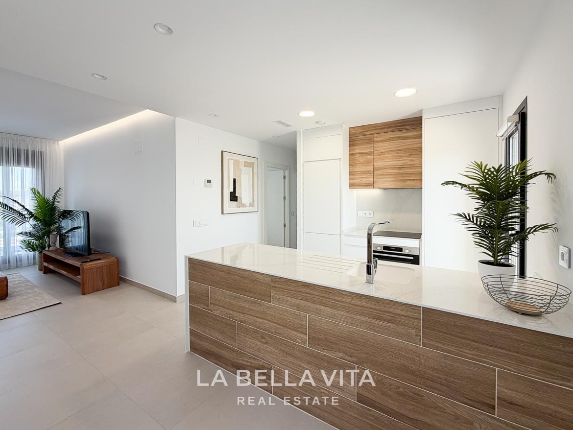 Modern Resale Apartment fot sale in Lo Romero Golf, Pilar de la Horadada, Alicante-16 Kitchen peninsula with a white worktop, inset sink and wood-effect front