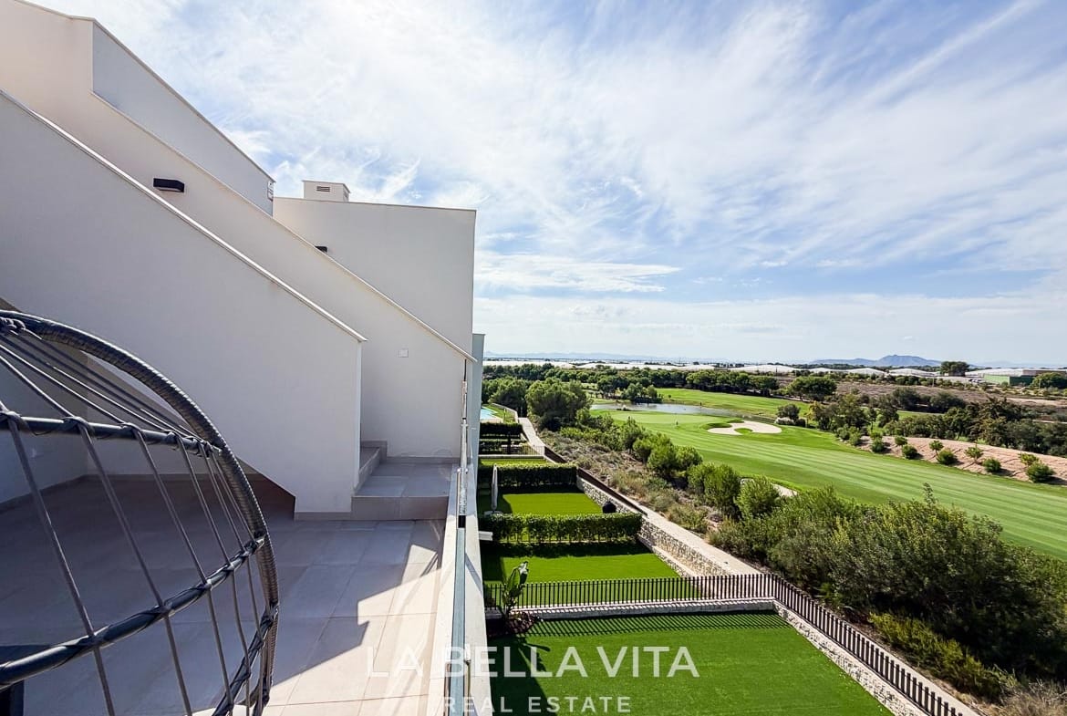 Glass-fronted terrace with a hanging chair and views across the golf course