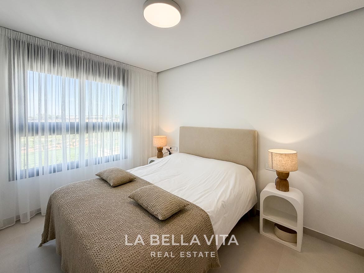 Modern Resale Apartment fot sale in Lo Romero Golf, Pilar de la Horadada, Alicante-20 Double bedroom with a beige upholstered headboard, bedside lamps and a large curtained window