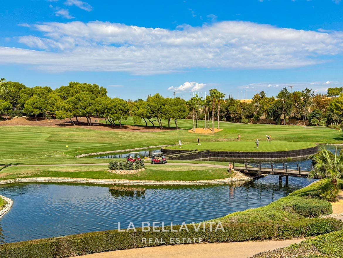 Modern Resale Apartment fot sale in Lo Romero Golf, Pilar de la Horadada, Alicante-47 Lo Romero Golf green surrounded by water, with a footbridge, golfers and golf buggies