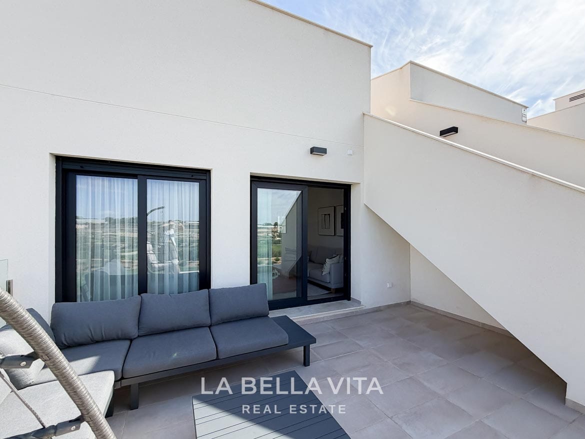 Modern Resale Apartment fot sale in Lo Romero Golf, Pilar de la Horadada, Alicante-5 Tiled terrace with a grey outdoor sofa, sliding doors and stairs to the roof solarium