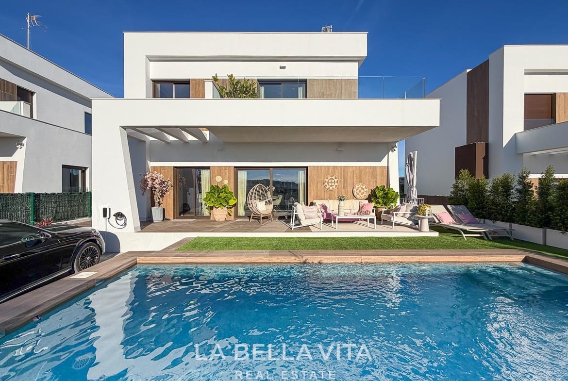 Front of the modern villa with private pool, covered seating terrace and upper balcony in Finestrat, Alicante.