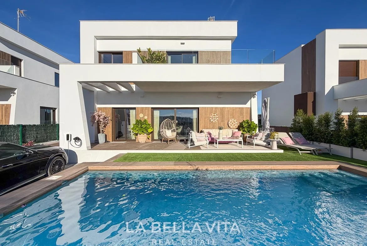 Front of the modern villa with private pool, covered seating terrace and upper balcony in Finestrat, Alicante.