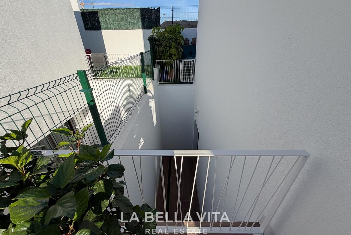 Exterior stairwell leading down to the basement with white railings in Finestrat, Alicante.