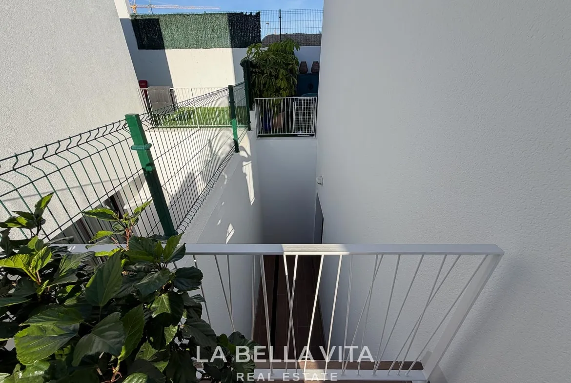 Exterior stairwell leading down to the basement with white railings in Finestrat, Alicante.