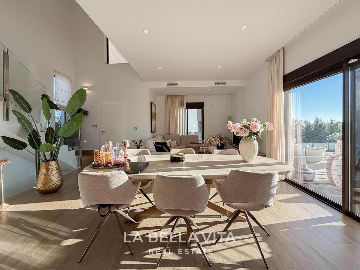 Modern Resale Villa with Basement and Private Pool for Sale in Finestrat-17 Dining table beside the terrace doors with the lounge beyond in Finestrat, Alicante.