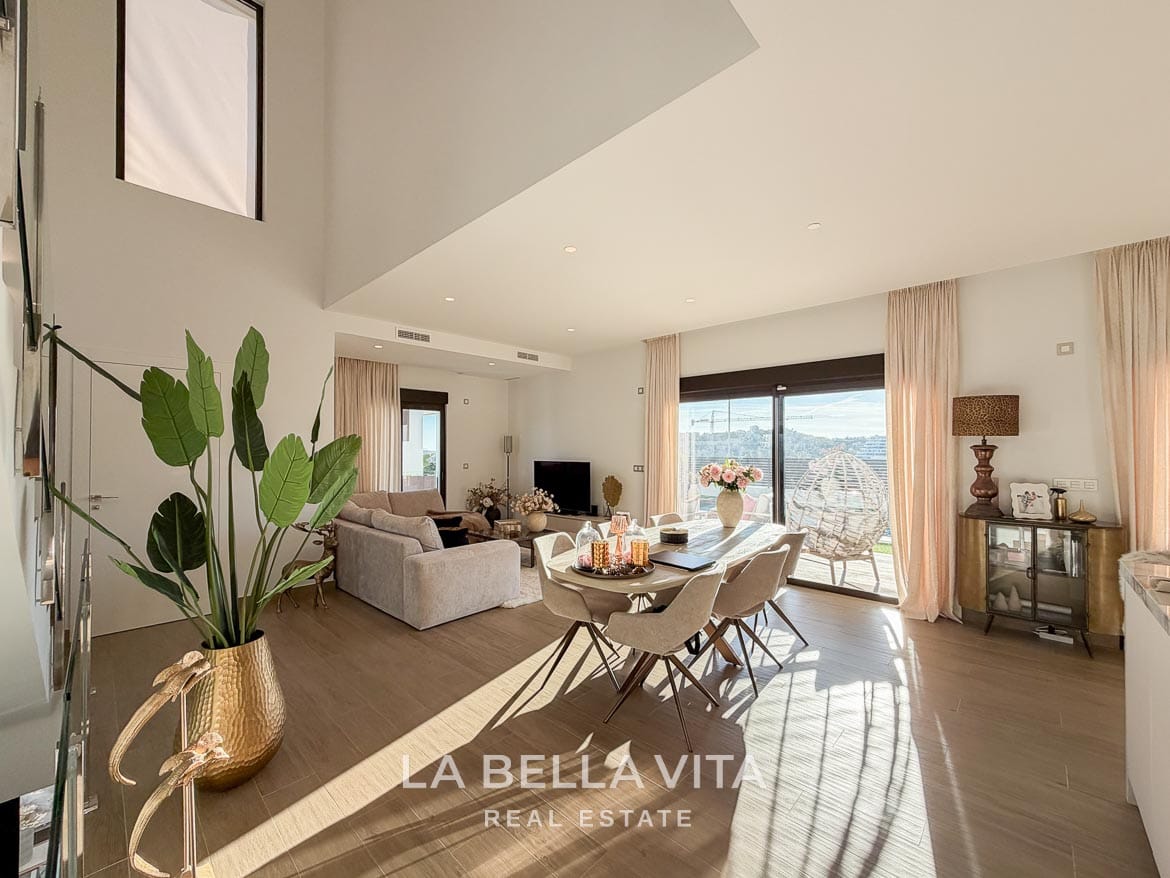 Modern Resale Villa with Basement and Private Pool for Sale in Finestrat-18 Open living and dining space with a tall stairwell window and terrace doors in Finestrat, Alicante.