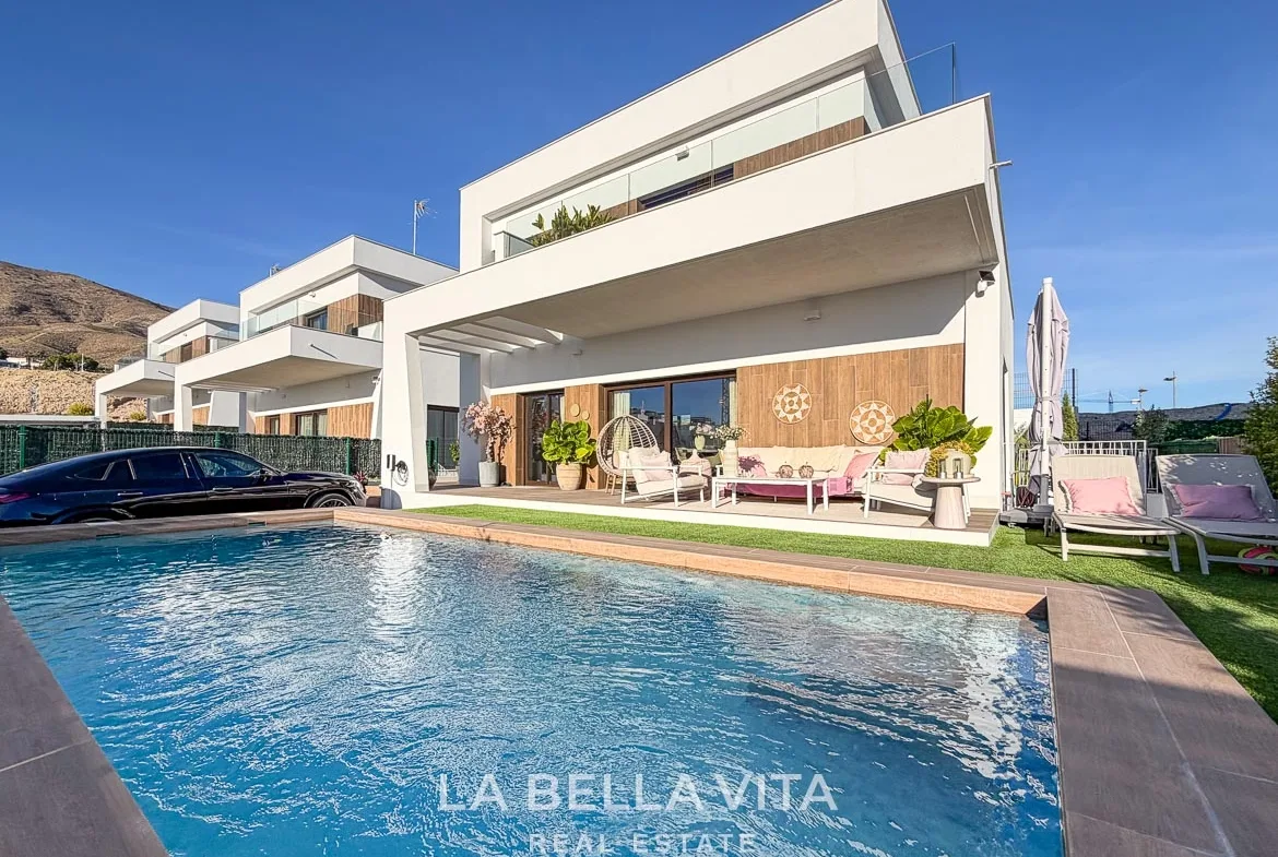 Private pool beside the white villa, covered terrace and sun loungers in Finestrat, Alicante.