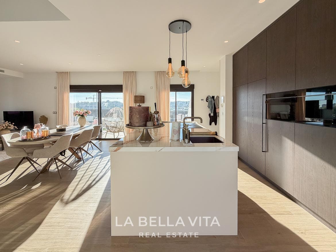 Modern Resale Villa with Basement and Private Pool for Sale in Finestrat-20 Kitchen island and wood-fronted cabinets with integrated ovens in Finestrat, Alicante.