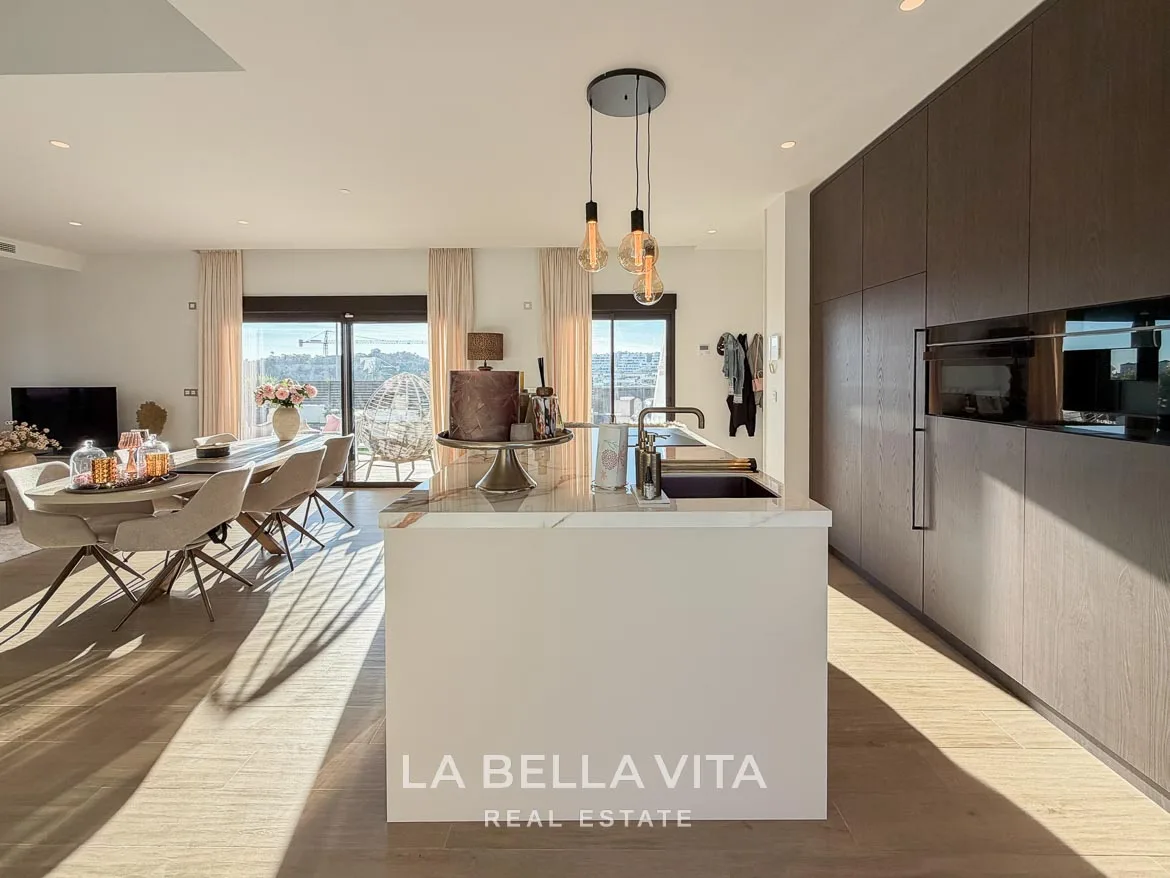 Modern Resale Villa with Basement and Private Pool for Sale in Finestrat-20 Kitchen island and wood-fronted cabinets with integrated ovens in Finestrat, Alicante.