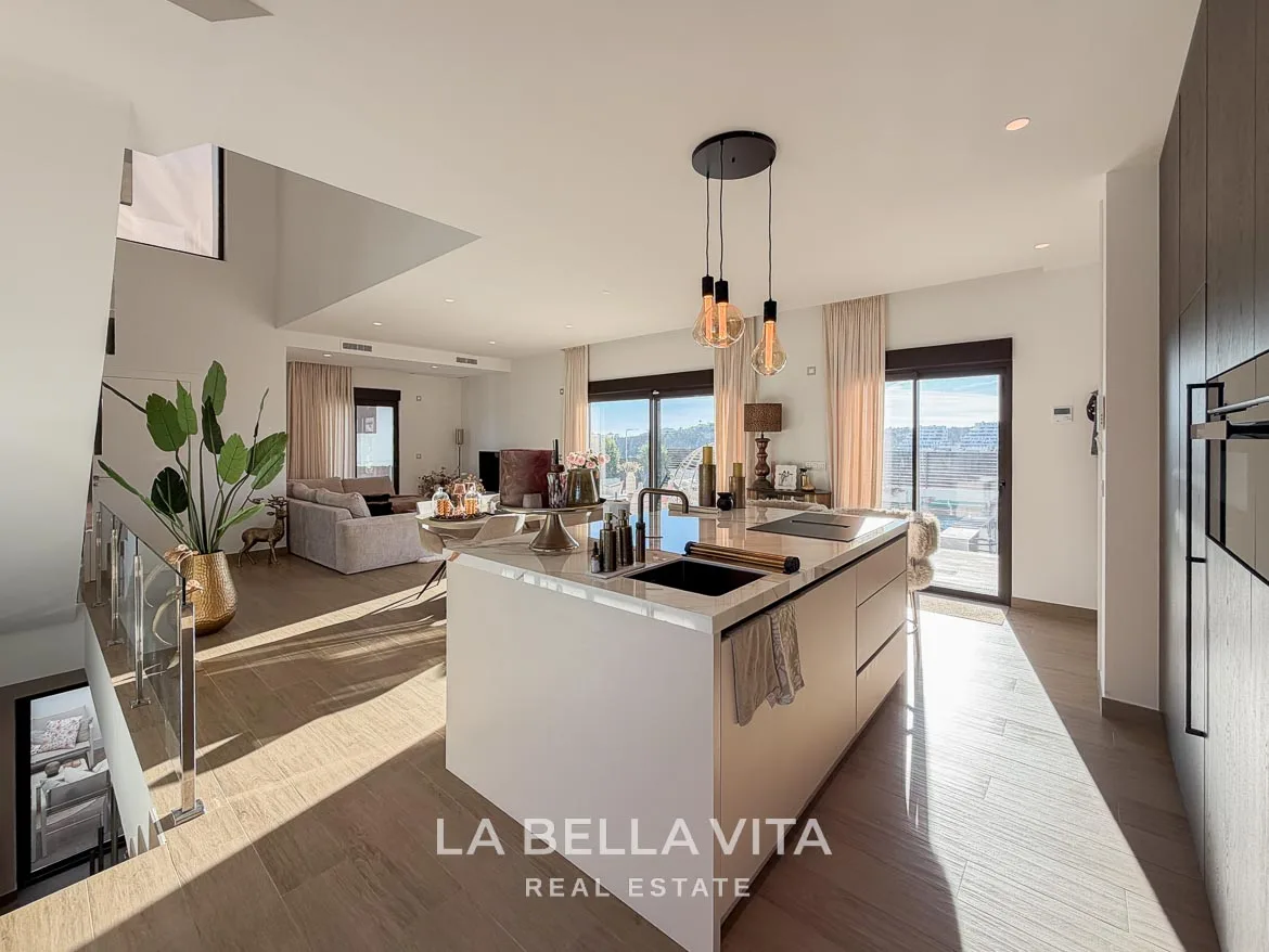 Modern Resale Villa with Basement and Private Pool for Sale in Finestrat-21 Kitchen island with sink and hob overlooking the staircase and dining area in Finestrat, Alicante.