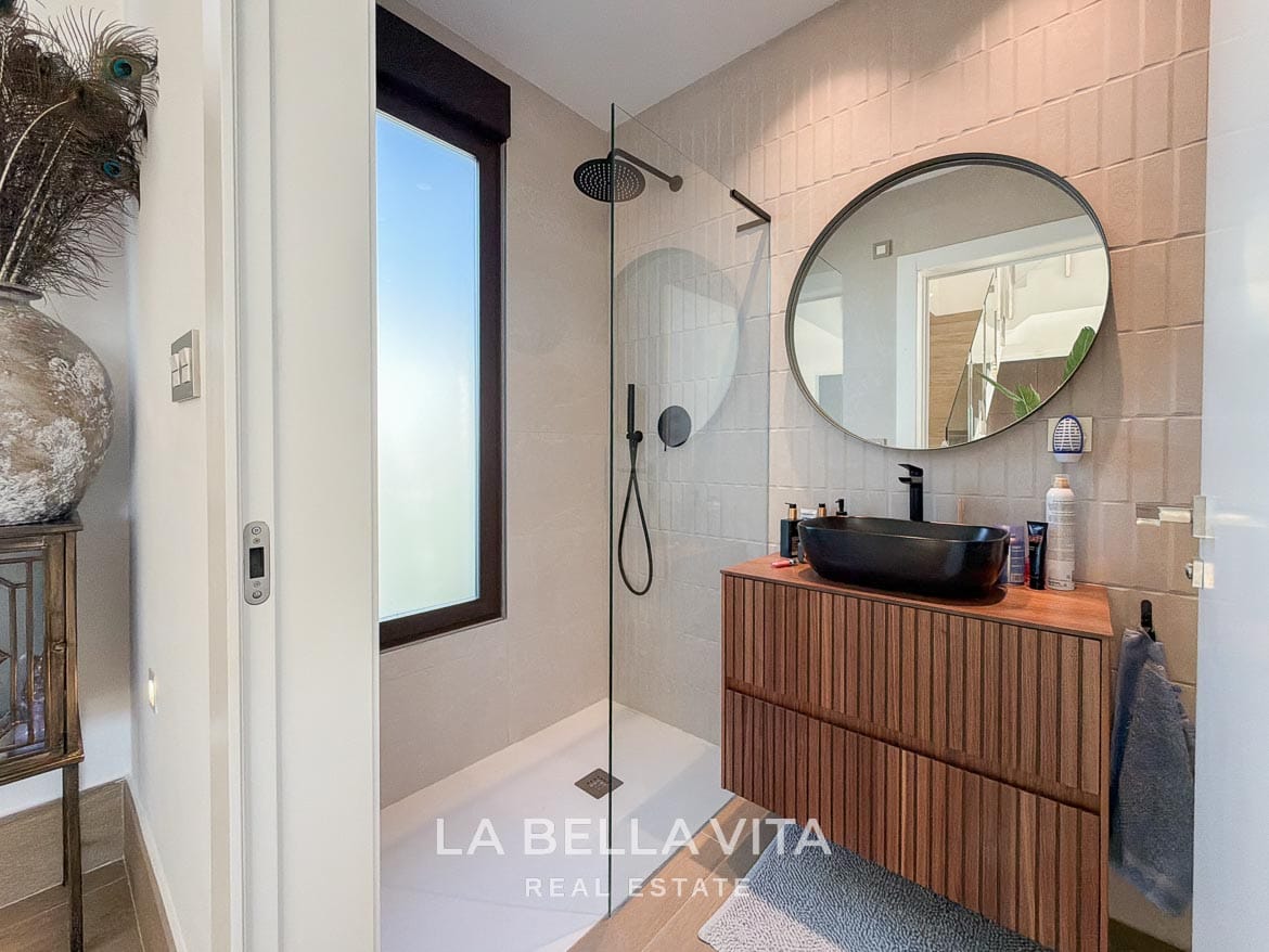 Modern Resale Villa with Basement and Private Pool for Sale in Finestrat-27 Shower room with a black basin, wooden vanity and round mirror in Finestrat, Alicante.