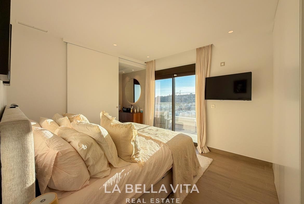 Double bedroom with sliding terrace doors and an adjoining bathroom in Finestrat, Alicante.