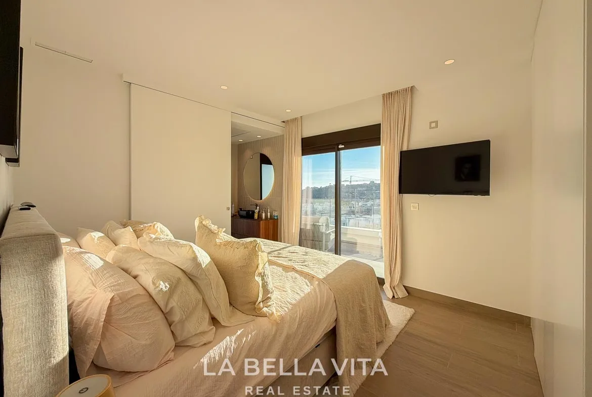 Double bedroom with sliding terrace doors and an adjoining bathroom in Finestrat, Alicante.
