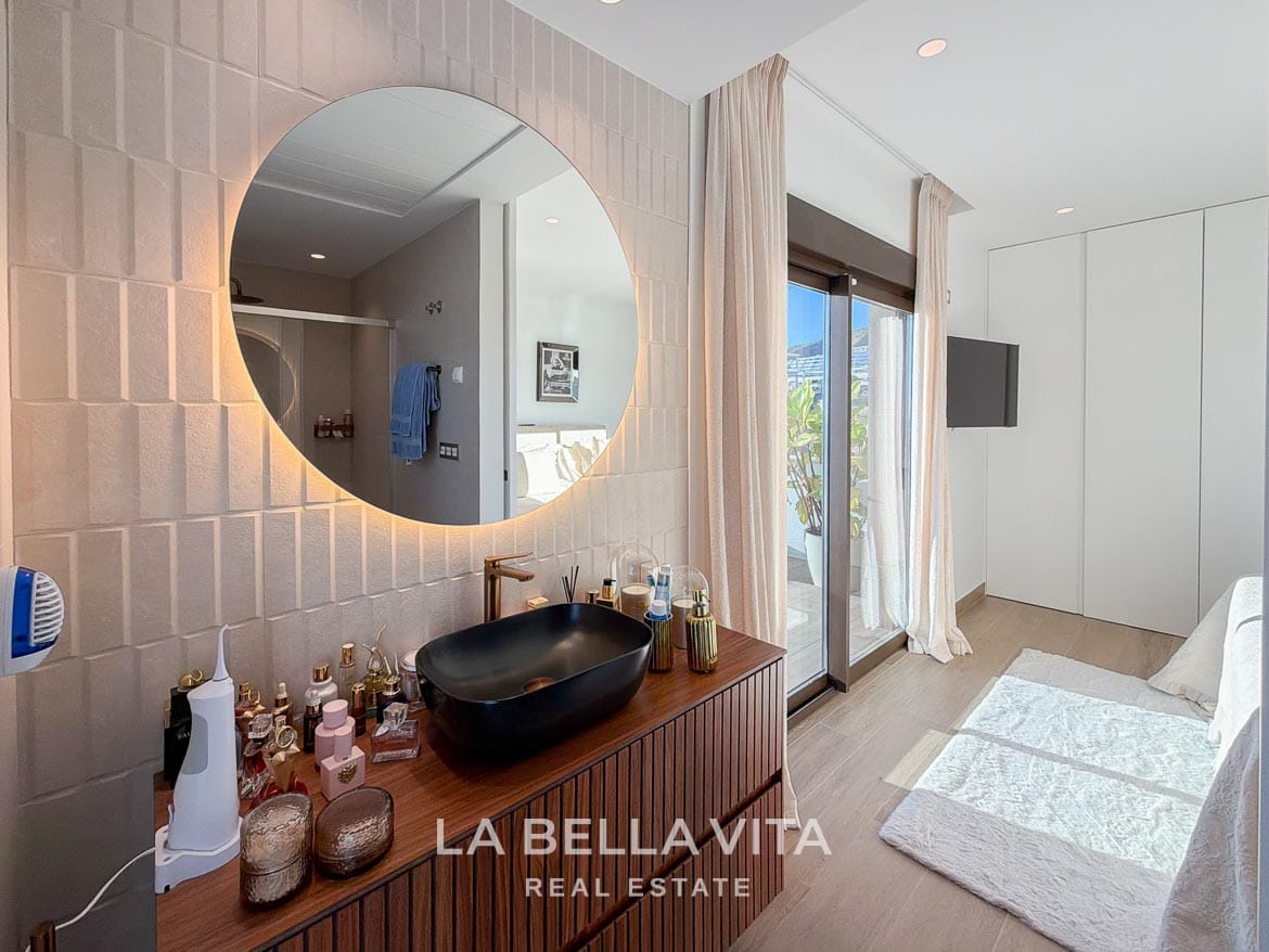 Modern Resale Villa with Basement and Private Pool for Sale in Finestrat-31 En-suite vanity with a black basin and illuminated mirror beside the bedroom in Finestrat, Alicante.