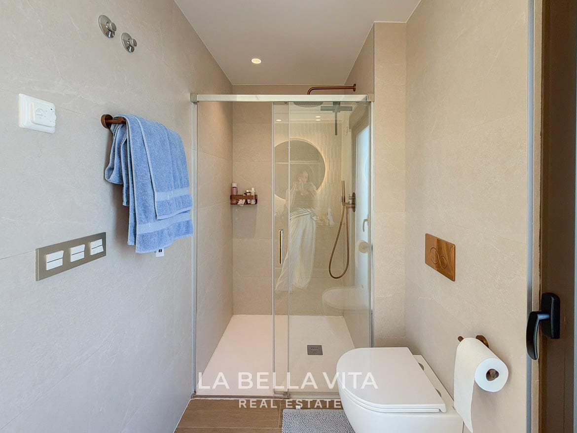 Modern Resale Villa with Basement and Private Pool for Sale in Finestrat-33 Glass shower enclosure and wall-hung toilet in the tiled bathroom in Finestrat, Alicante.