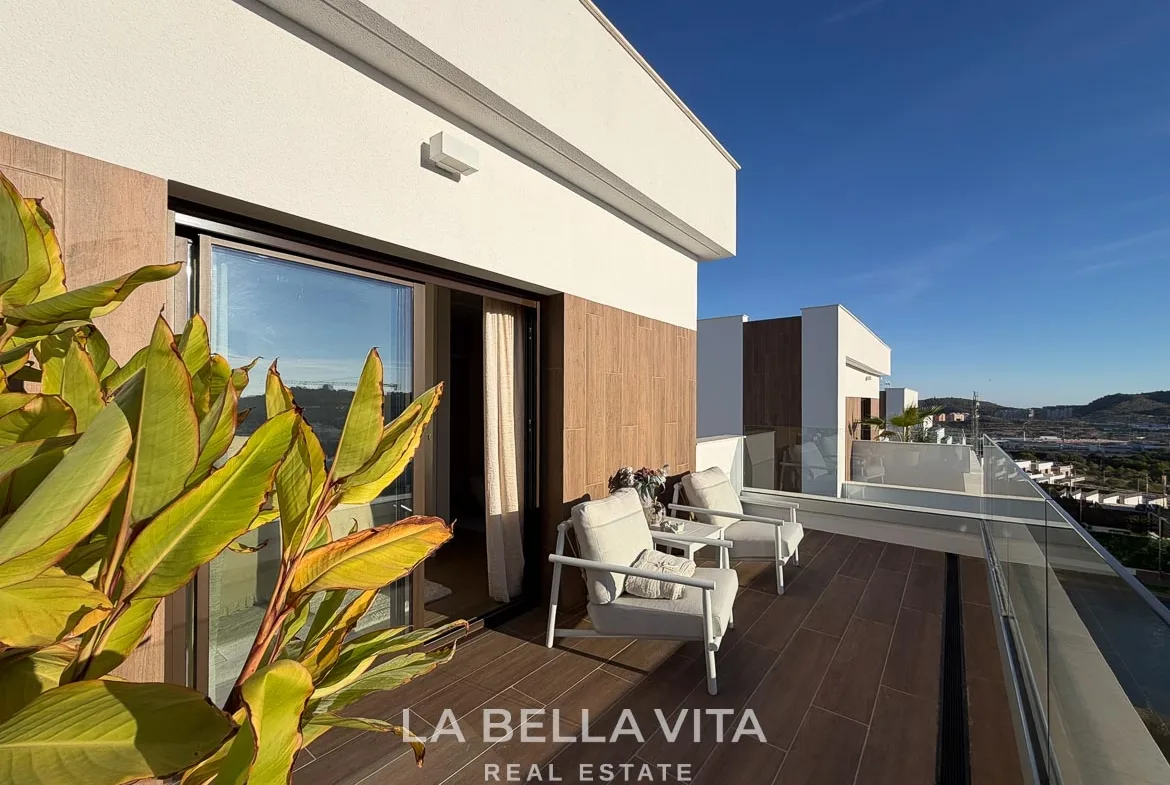 Upper terrace with two armchairs, plants and a glass balustrade in Finestrat, Alicante.