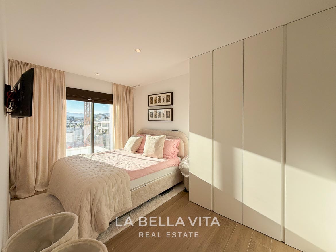 Modern Resale Villa with Basement and Private Pool for Sale in Finestrat-36 Bedroom with pink bedding, fitted white wardrobes and sliding terrace doors in Finestrat, Alicante.