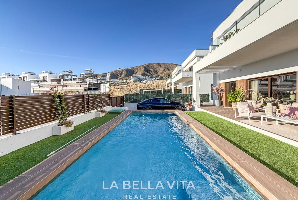 Lengthwise view of the private pool beside the covered terrace and boundary fence in Finestrat, Alicante.