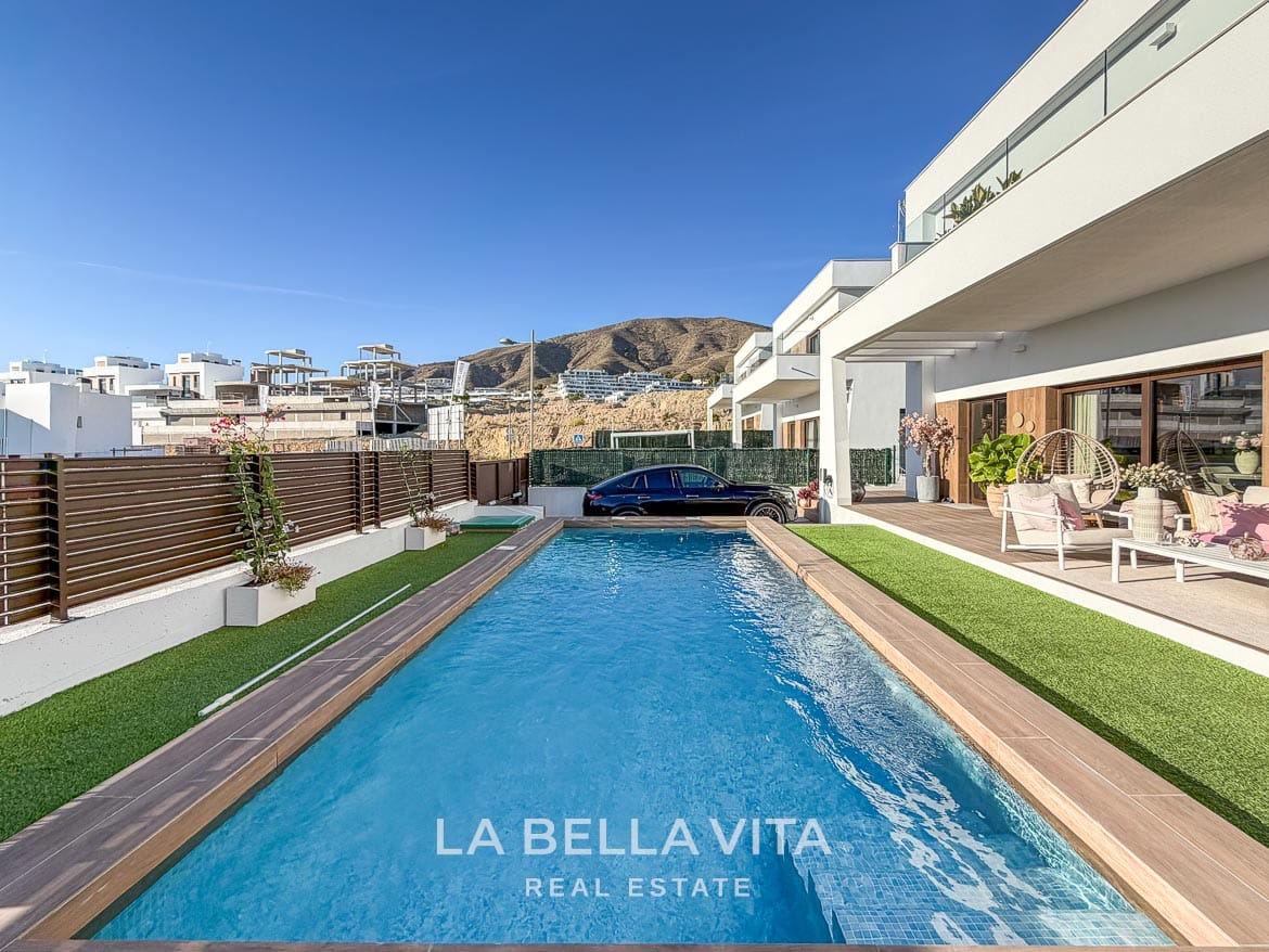 Modern Resale Villa with Basement and Private Pool for Sale in Finestrat-4 Lengthwise view of the private pool beside the covered terrace and boundary fence in Finestrat, Alicante.
