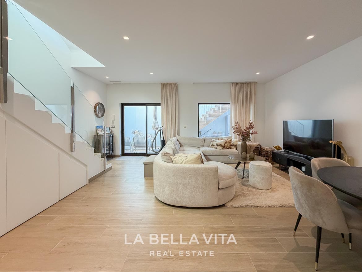 Modern Resale Villa with Basement and Private Pool for Sale in Finestrat-41 Basement lounge with a curved sofa and glazed doors opening onto the sunken patio in Finestrat, Alicante.