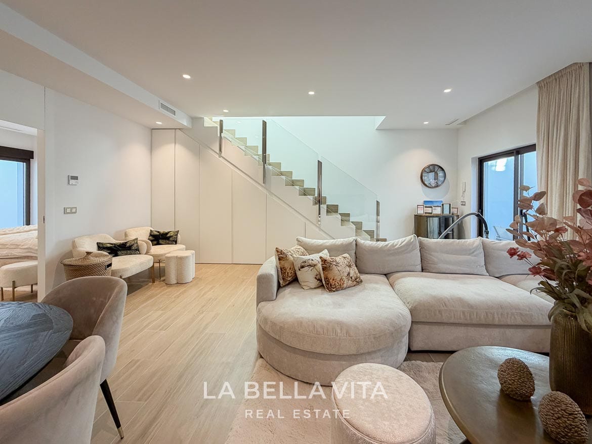 Modern Resale Villa with Basement and Private Pool for Sale in Finestrat-43 Basement seating area with a curved sofa and fitted storage beneath the stairs in Finestrat, Alicante.