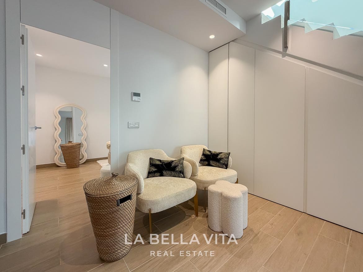 Modern Resale Villa with Basement and Private Pool for Sale in Finestrat-45 Pair of armchairs beside fitted under-stair storage in the basement in Finestrat, Alicante.