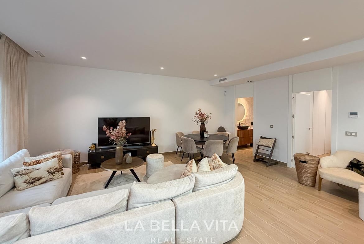 Basement living room with a curved sofa, coffee table and dining area in Finestrat, Alicante.