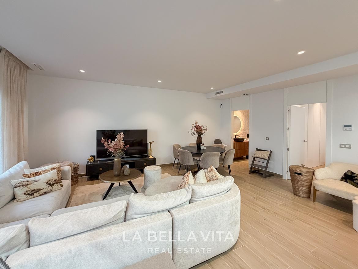 Modern Resale Villa with Basement and Private Pool for Sale in Finestrat-46 Basement living room with a curved sofa, coffee table and dining area in Finestrat, Alicante.