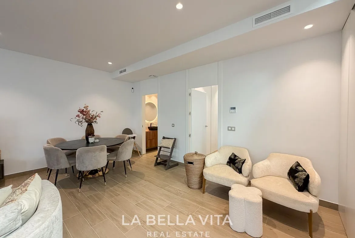 Basement dining area and two armchairs beside the adjoining rooms in Finestrat, Alicante.