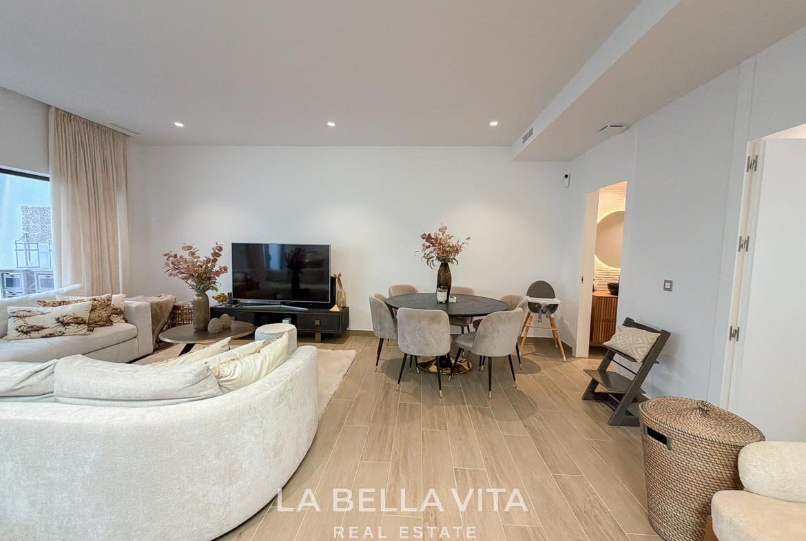 Basement lounge with a television and dining table beside the bathroom entrance in Finestrat, Alicante.