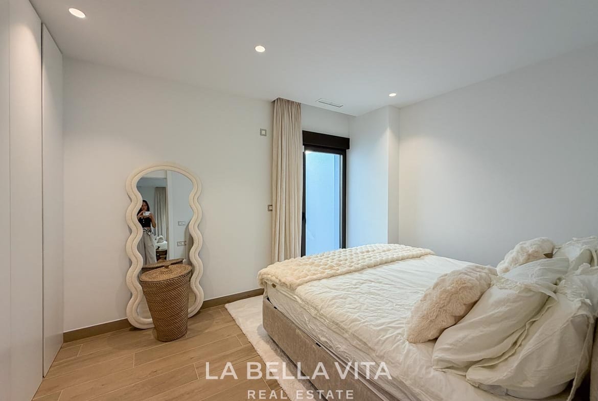 Basement double bedroom with fitted wardrobes and a full-length mirror in Finestrat, Alicante.