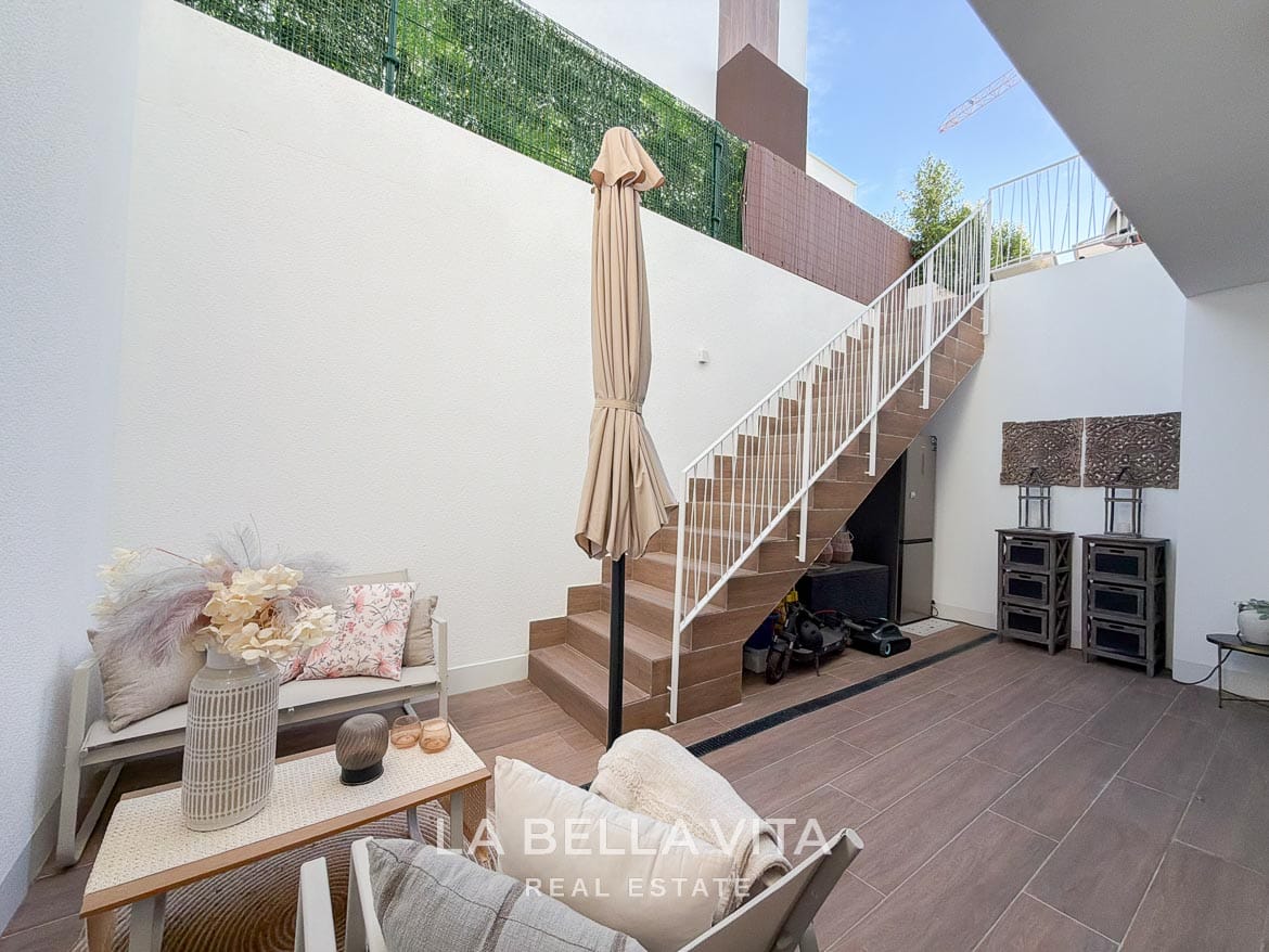 Modern Resale Villa with Basement and Private Pool for Sale in Finestrat-53 Sunken patio with outdoor seating and an external staircase to the garden in Finestrat, Alicante.