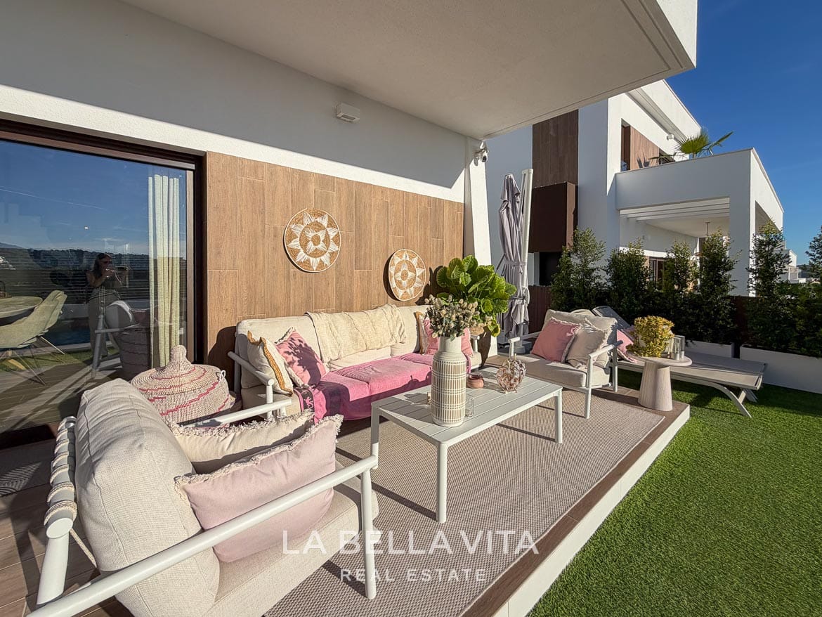 Modern Resale Villa with Basement and Private Pool for Sale in Finestrat-6 Covered outdoor seating area with a sofa, armchairs and pink cushions in Finestrat, Alicante.