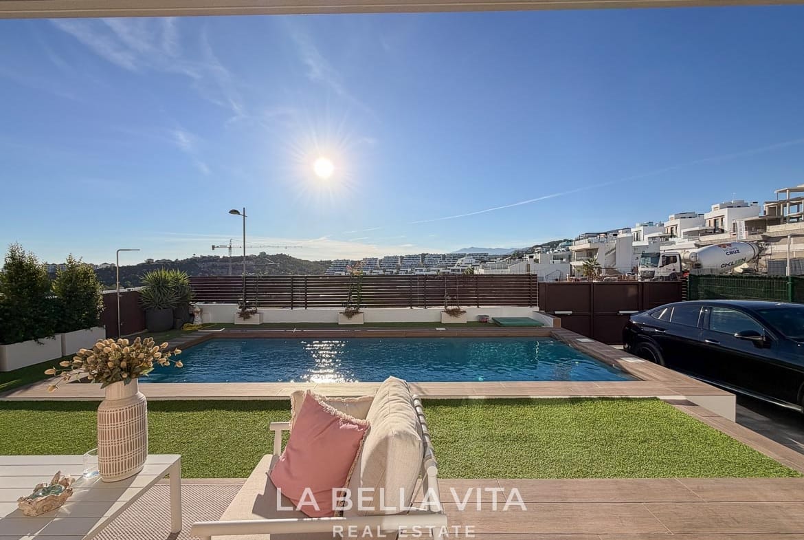 View from the covered seating terrace across the pool and garden in Finestrat, Alicante.
