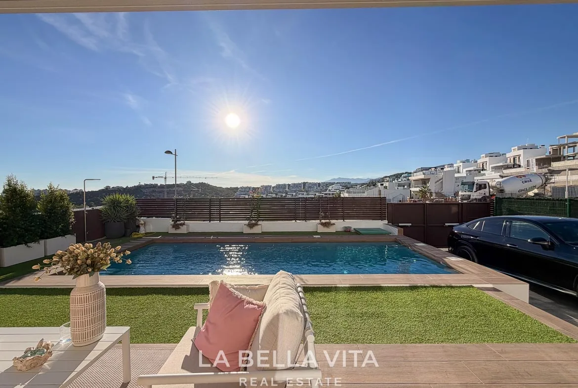 View from the covered seating terrace across the pool and garden in Finestrat, Alicante.