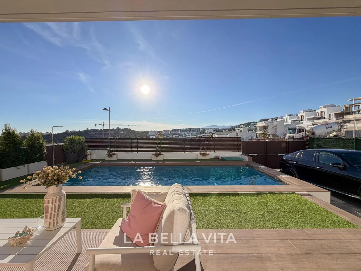 Modern Resale Villa with Basement and Private Pool for Sale in Finestrat-7 View from the covered seating terrace across the pool and garden in Finestrat, Alicante.