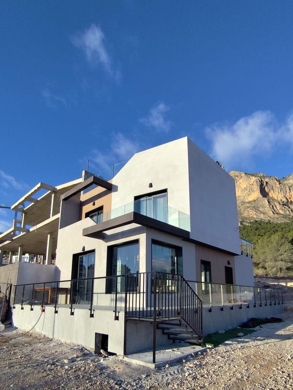 NEW BUILD SEMI-DETACHED VILLAS IN POLOP Exterior of a show home with terraces and mountain surroundings in Polop, Alicante