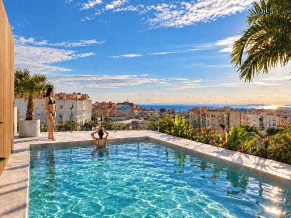 Communal rooftop pool with glass railing and town skyline in Santa Pola, Alicante